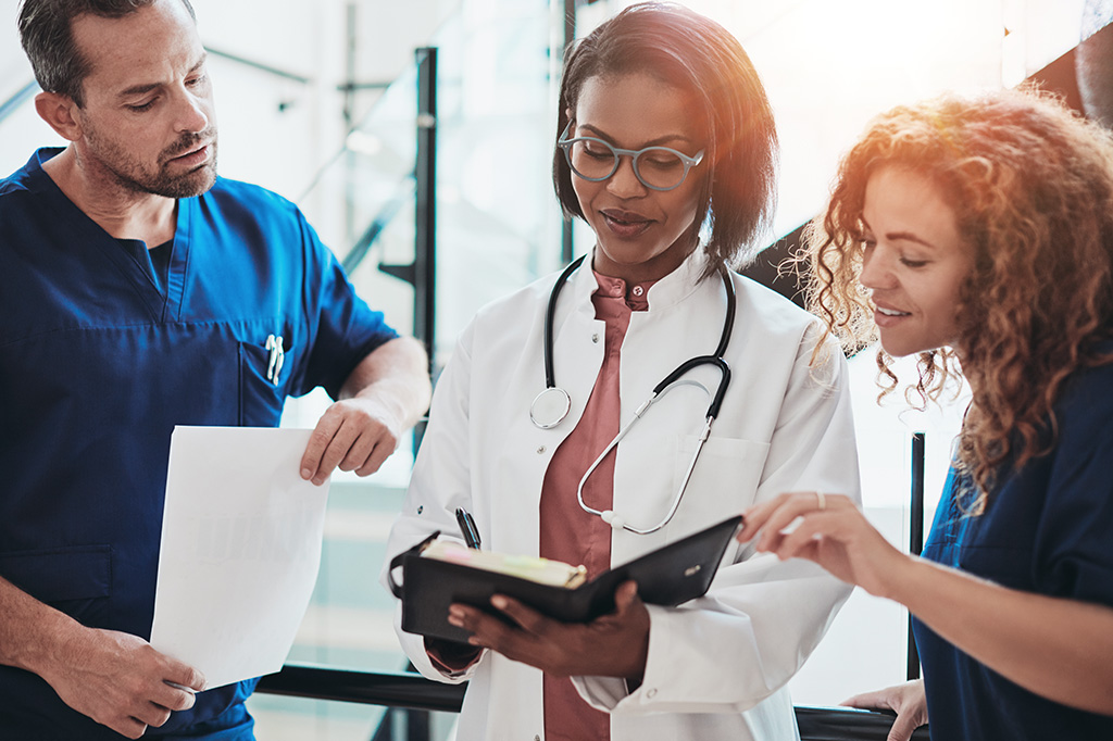 three doctors looking at a notebook