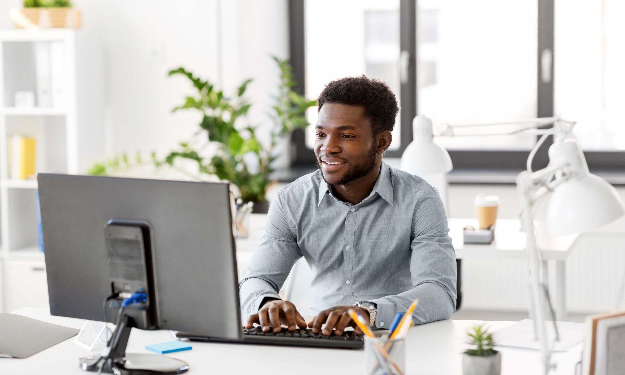 an african american man working at a computer in an office