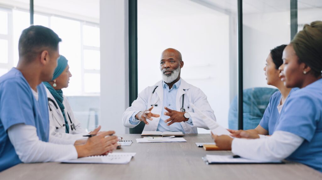 a group of doctors sitting at a conference table.