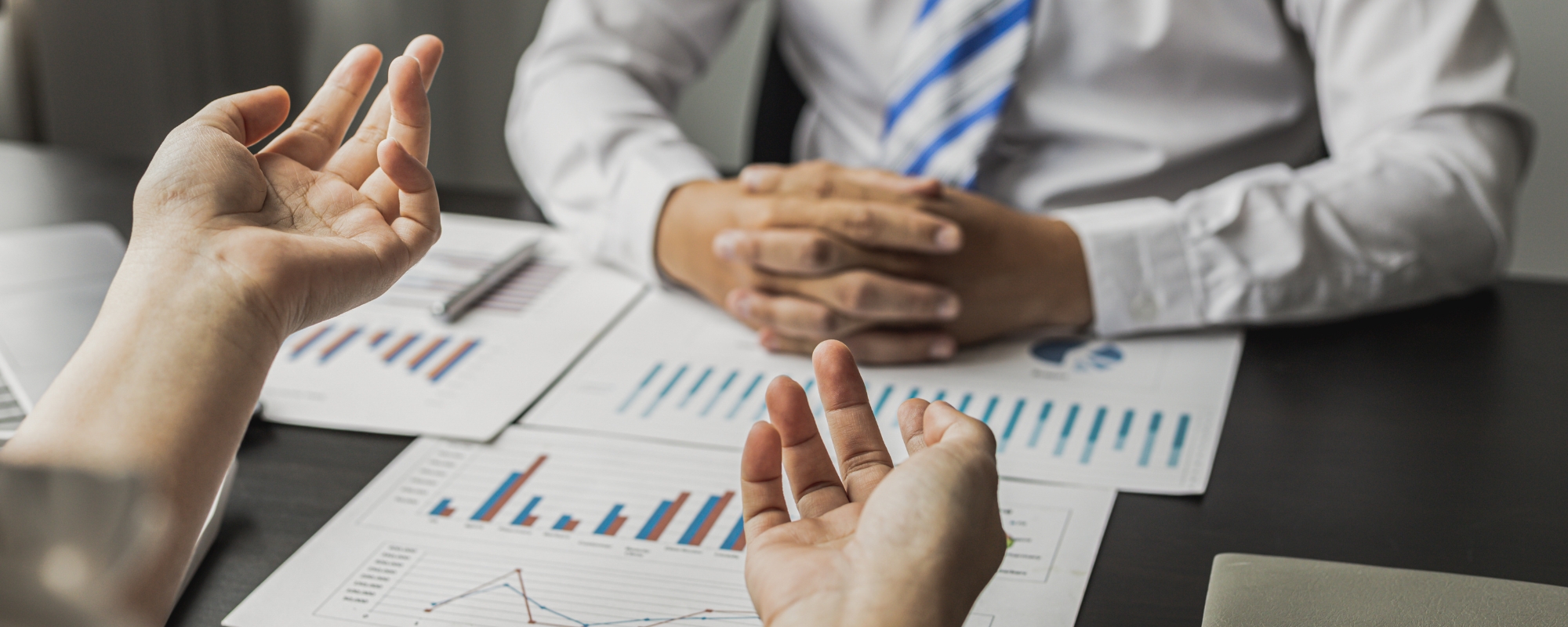 two people sitting at a table with graphs and papers