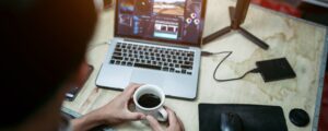 a person sitting at a desk with a laptop and a cup of coffee