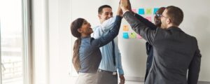 a group of business people in an office giving each other high fives