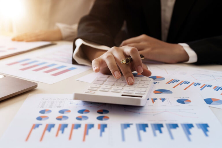 woman in a business suit calculating marketing budget at a desk