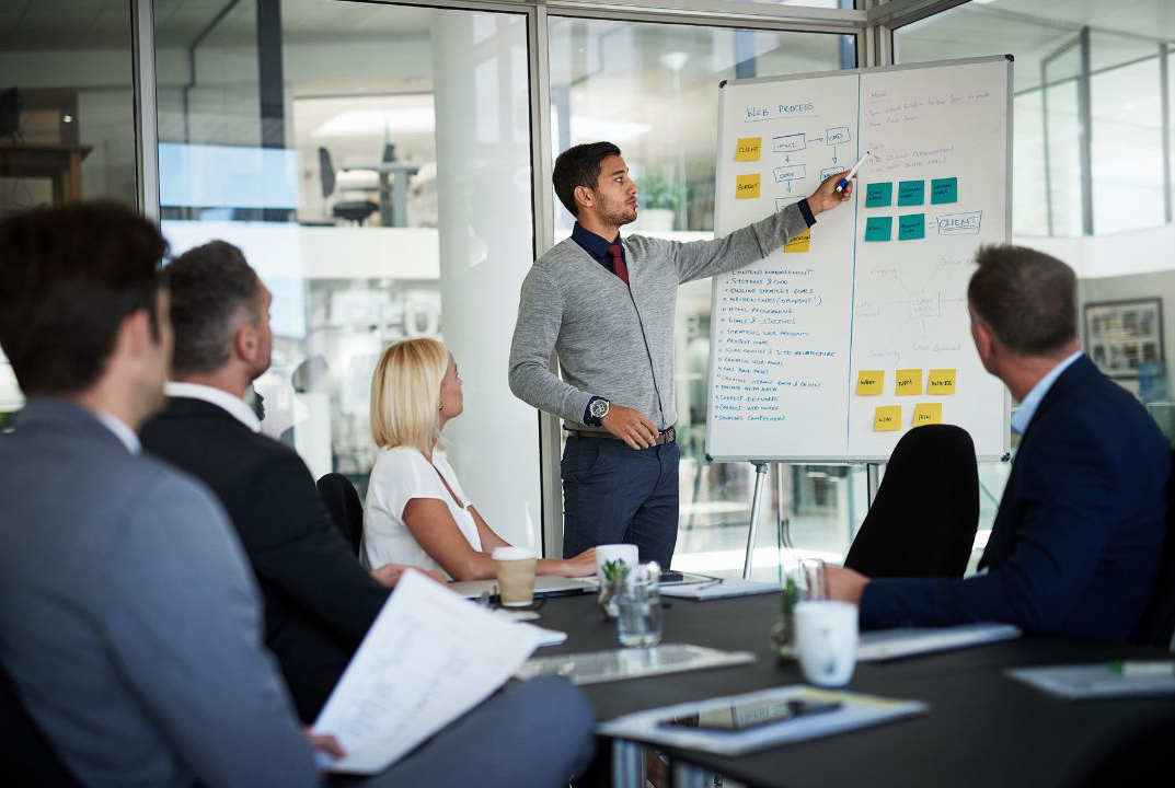 person giving an inside sales presentation to a group in an office setting